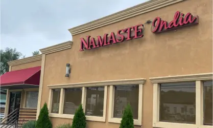 Exterior of Namaste India restaurant in Mahwah with beige walls, large front windows, and a red awning over the entrance.